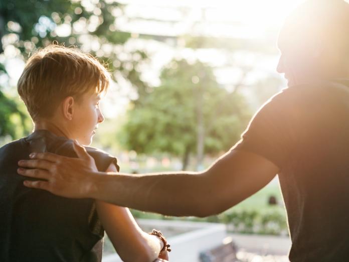 Far ligger hånden på ryggen af sin søn
