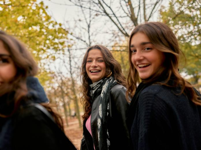 Tre teenagepiger smiler