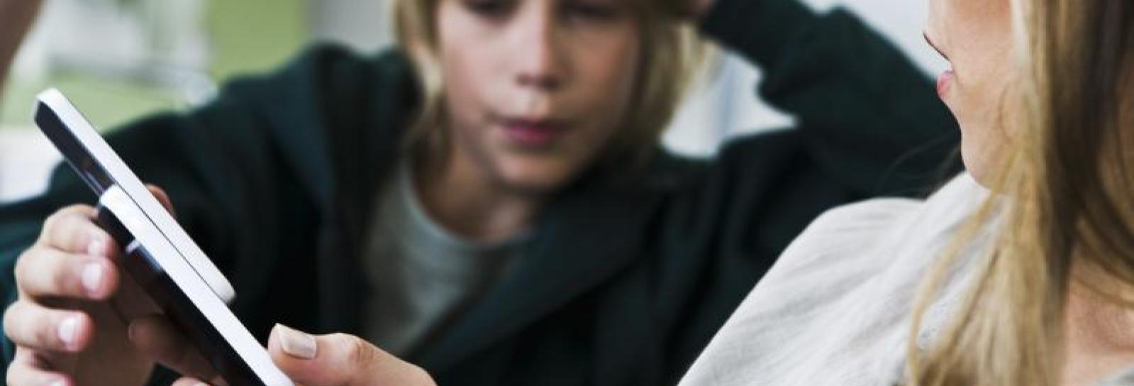 En teenager sidder på sin mobiltelefon