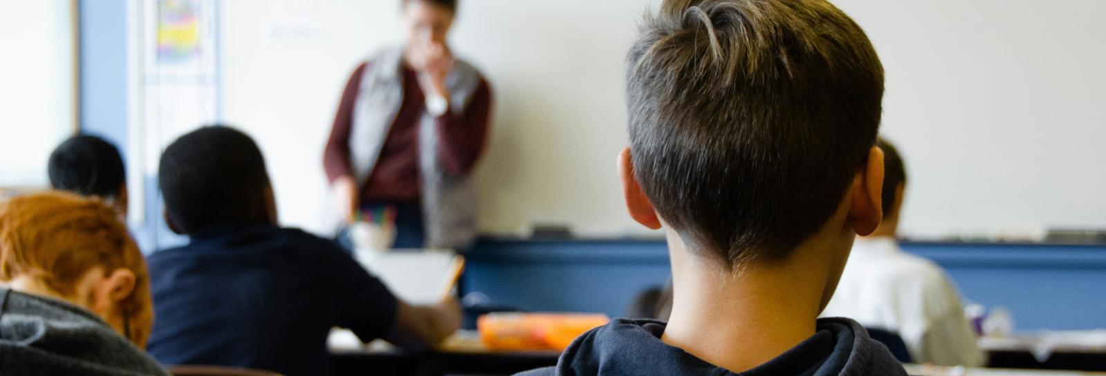 Nakken af en dreng der sidder til undervisning