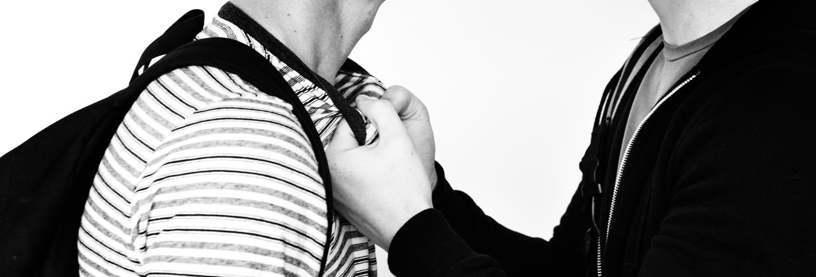 En dreng der tager fat i en anden drengs bluse med knyttede næver