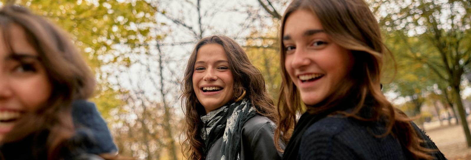 tre teenagepiger der smiler