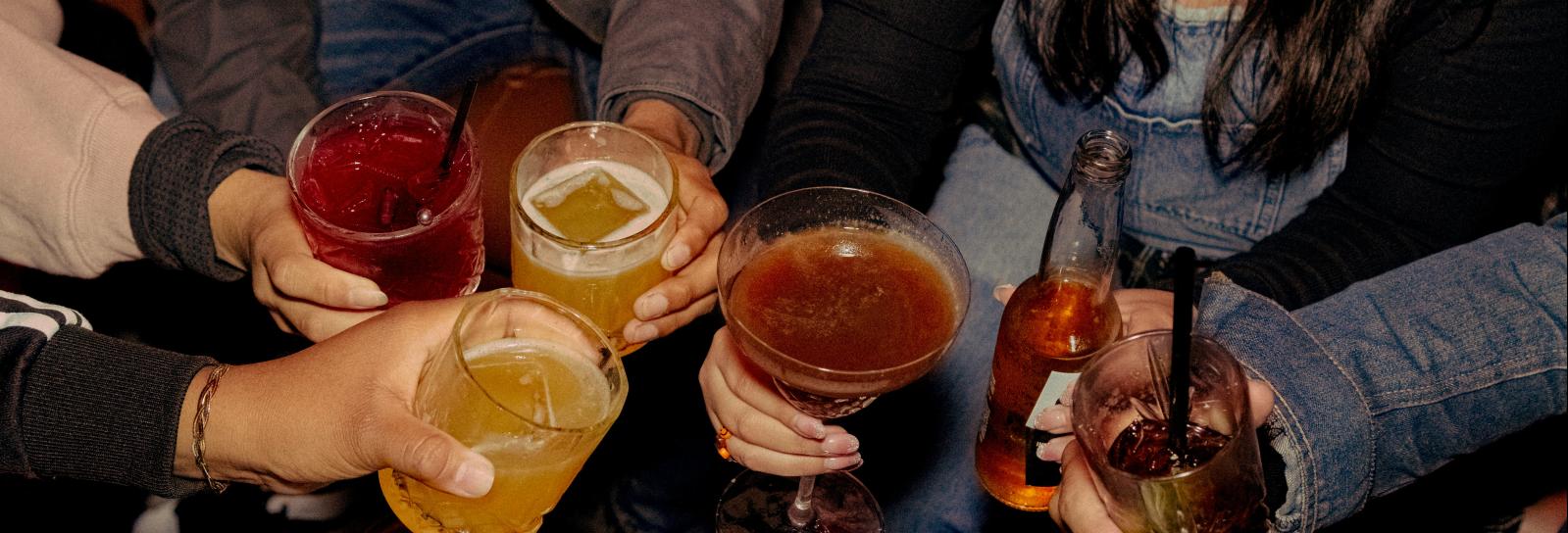 seks personer der skåler i drinks